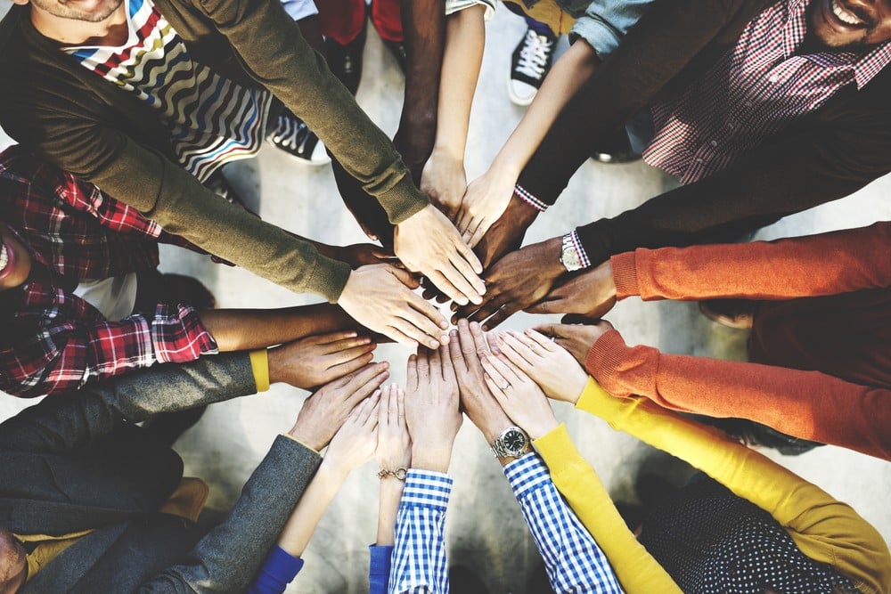 How to Create an Inclusive Employee Benefits Package That Supports Diversity | FlexGenius | Circle of hands of different colours
