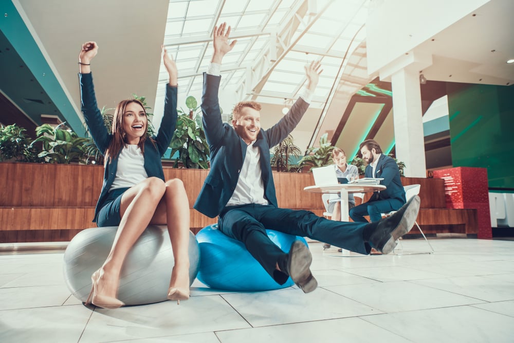 3 Workplace Wellness Trends HR Professionals Should Know | FlexGenius | Employees celebrating on beanbags